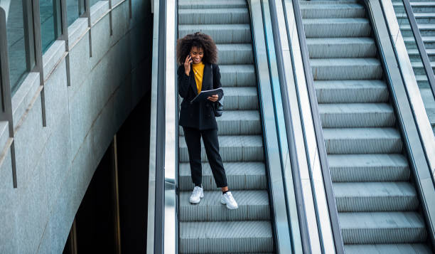 istock Businesswoman on escalator 1190865216