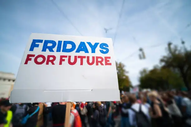 low perspective of fridays for future sign at protest march against climate change demonstration with many blurred people in the background