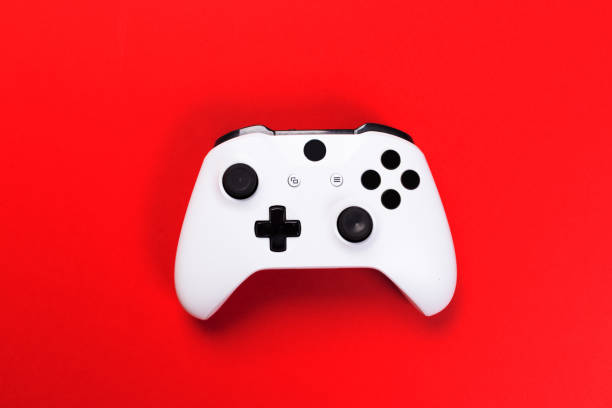 joystick kontroler do gier izolowane na czerwonym tle, konsola do gier wideo opracowany interactive entertainment - video game gamepad black isolated on white zdjęcia i obrazy z banku zdjęć