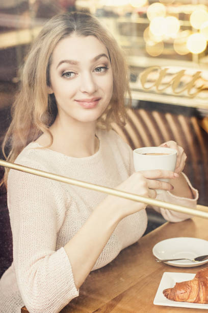 istock Blonde woman drinking coffee and smiling 1190868325