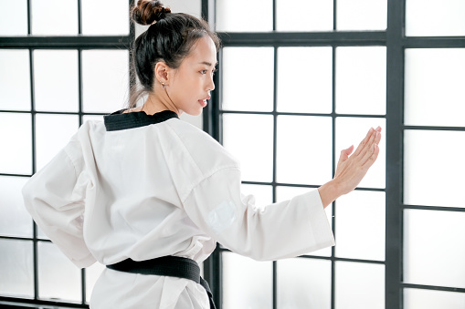 Young teacher of taekwondo show some posture that use hand fight forward to the opposite.