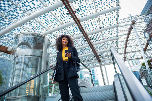 istock Businesswoman standing on escalator 1190871118