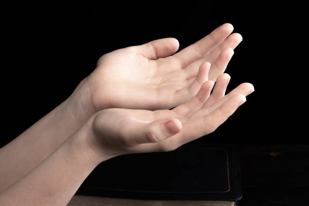 istock Praying hands is in the dark with light on the hands 1190877252