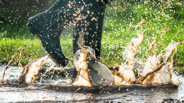 istock green wellington splashing in wet puddles 1190884121
