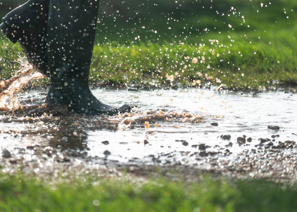 istock person walking in a large muddy puddle with boots 1190884166