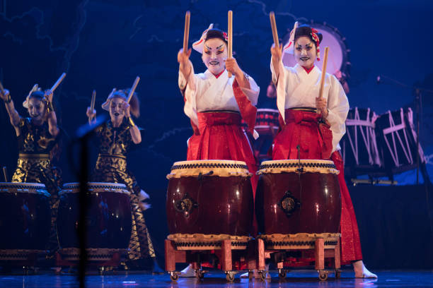 traditionelle japanische aufführung. gruppe von schauspielerinnen in traditionellen kimono und fuchs masken trommel taiko trommeln auf der bühne. - taiko drum stock-fotos und bilder