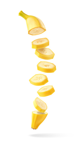 Flying fresh ripe banana slices isolated on white background