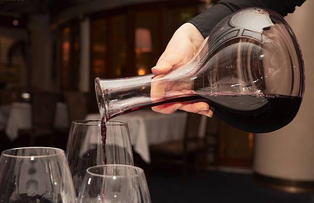 официант заливки красный вино из декантер - wine decanter red restaurant стоковые фото и изображения