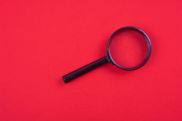 istock Black magnifier on a red background. Free space for an inscription. 1190892827