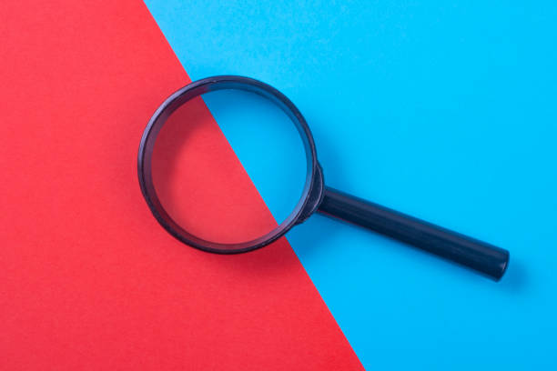 istock Black magnifier on a blue and red background. Free space for an inscription. 1190892881