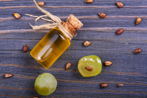 istock Bottle with grape oil and grape seeds on a wooden table. 1190893958