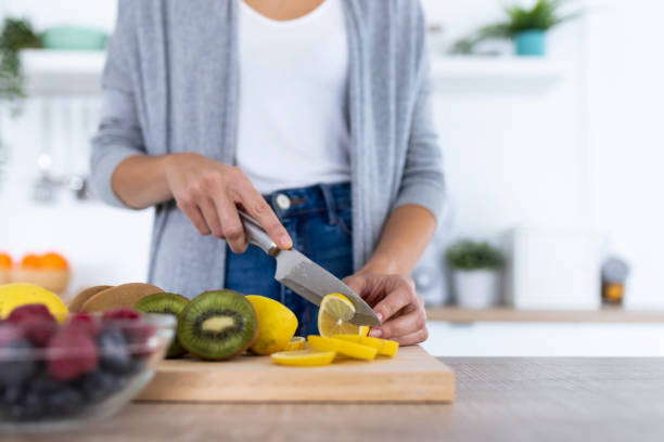 istock Woman's hands while she cutting lemon over wooden table in the kitchen. 1190897378