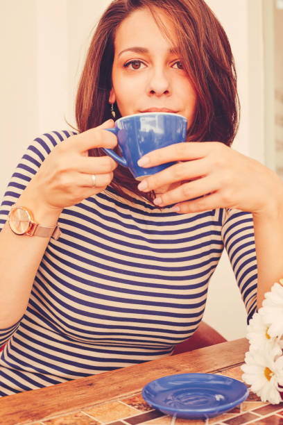istock Beautiful woman using cellphone and drink coffee outdoors. 1190897475