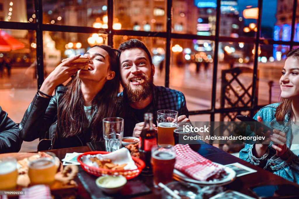 Cute Couple Enjoying Dinner Party With Friends Eating Stock Photo