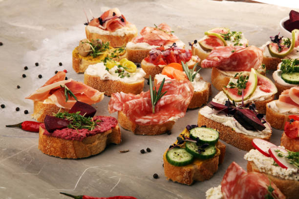 istock Assorted bruschetta with various toppings. Appetizing bruschetta or brie crostini. Variety of small sandwiches. Mix bruschetta on table 1190904663