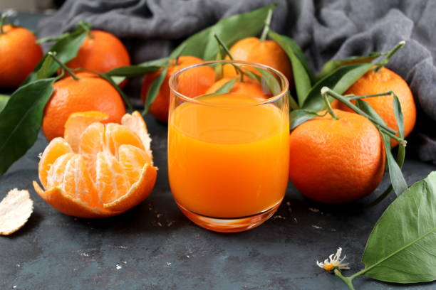 Glass of fresh tangerine juice with ripe tangerines. stock photo
