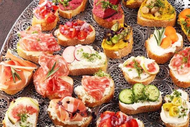 istock Assorted bruschetta with various toppings. Appetizing bruschetta or brie crostini. Variety of small sandwiches. Mix bruschetta on table 1190905373