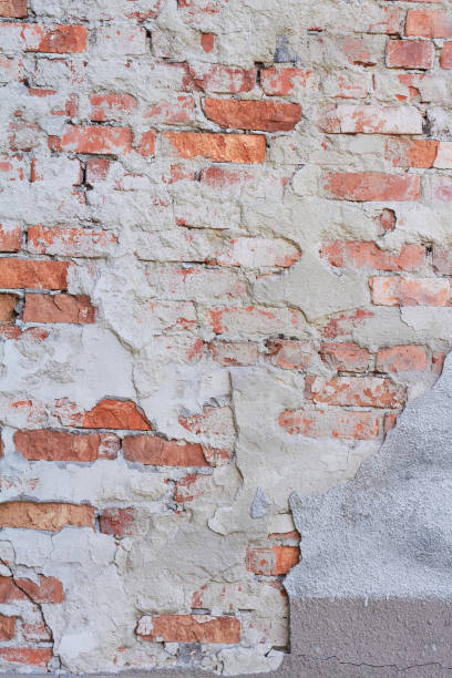 istock Old weathered red brick wall fragment, crumbling plaster 1190905520