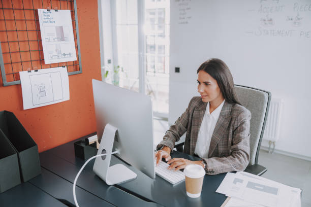 istock Smiling young woman is working in modern office 1190906573