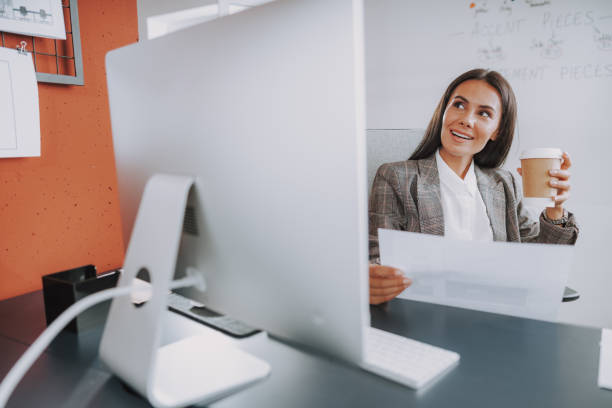 istock Smiling young lady hilding document in hand 1190906616