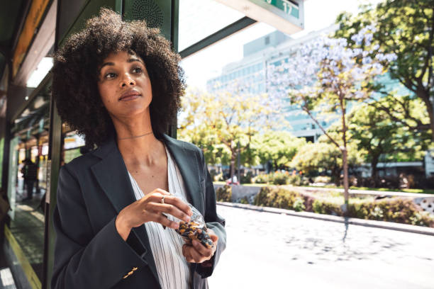 business afro american woman at bus stop in downtown - lanche da tarde imagens e fotografias de stock