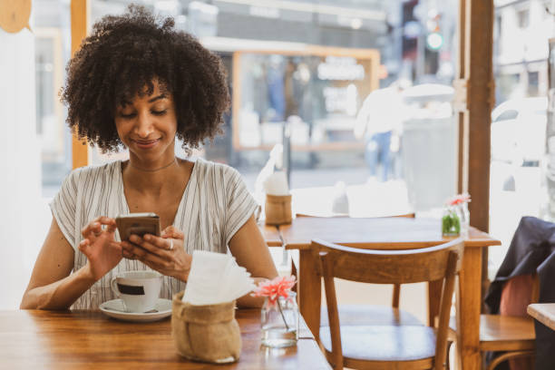istock Young woman smiling during coffee break chatting on mobile 1190909202