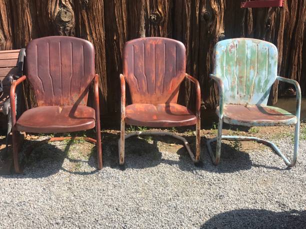 Abandoned Chairs Three rusted chairs in front of old farm rusty old wagon detail stock pictures, royalty-free photos & images