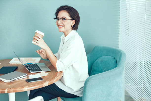 istock Happy lady is enjoying hot drink at workplace 1190914343