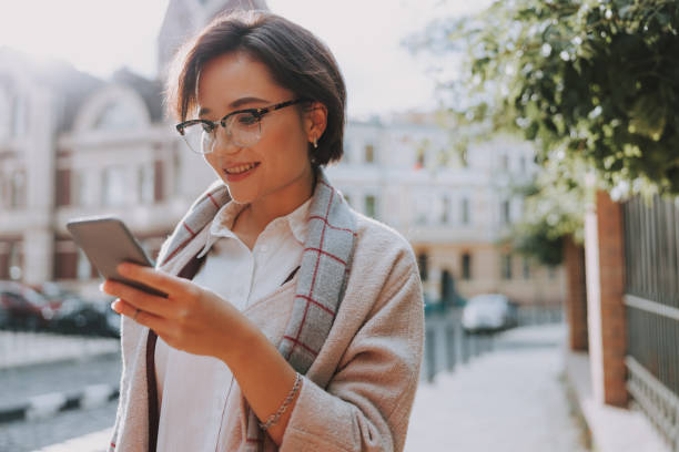istock Smiling young woman is typing on phone 1190916664