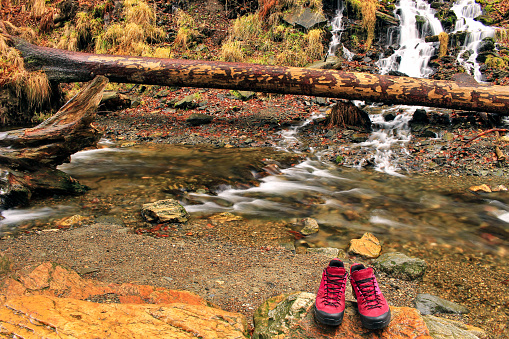 River and waterfall in the forest and Hiking shoes