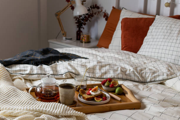 istock Breakfast in bed with pastry and fresh fruits, black tea 1190917567