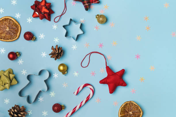 istock Christmas composition flat lay, gingerbread, cookie cutter, candy cane, dried orange, ornaments, pinecone on light blue background 1190917871