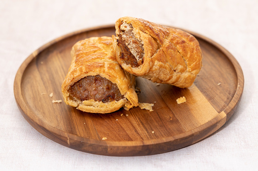 Sausage rolls on a wooden plate