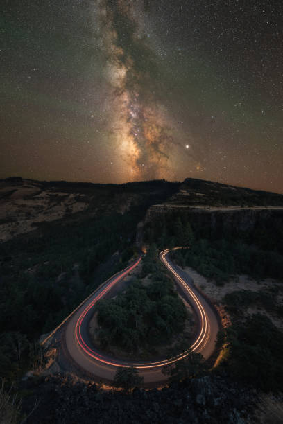 istock Milky Way Galaxy over Rowena Crest View Point with passing car lights 1190923555