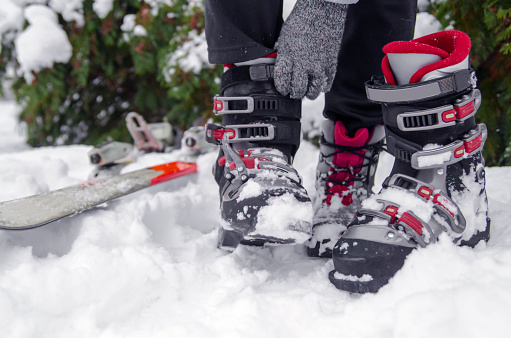 Woman put on ski shoes on snow.Close up wearing ski shoes on mountain slope