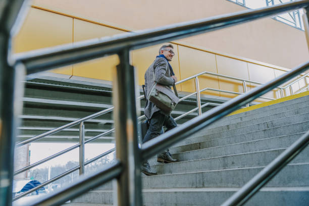 istock Handsome smiling man walking up the stairs 1190935496