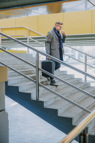 istock Good-looking man walking down the stairs and drinking coffee 1190935498