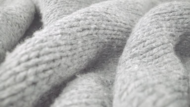 Extreme detail view of sheep wool cloth texture flowing in macro dolly shot.