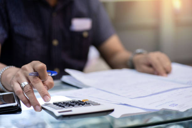 istock Man using calculator for calaulating finance, tax, accounting, statistics and analytic reserch concept 1190950623