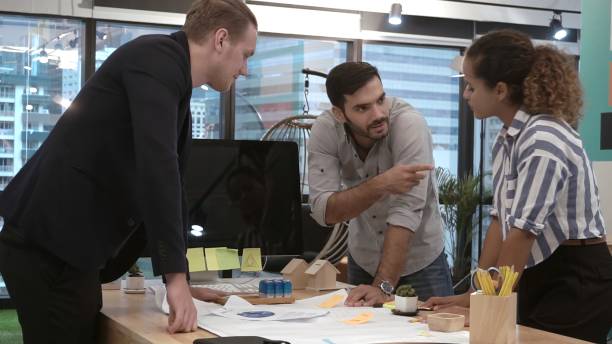 istock Creative business people group having conversation at office desk in workplace. 1190951868