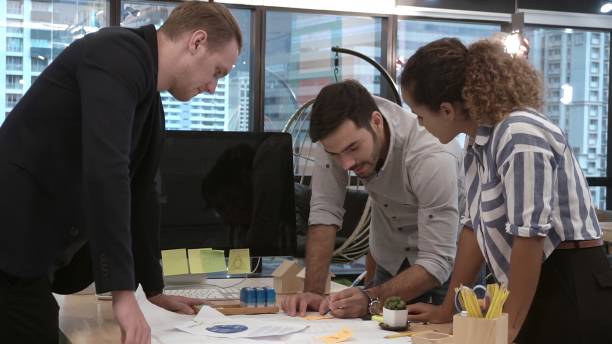 istock Creative business people group having conversation at office desk in workplace. 1190951879