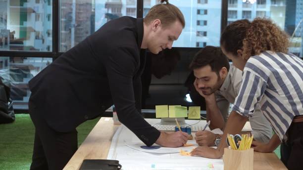 istock Creative business people group having conversation at office desk in workplace. 1190951934