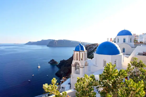 The Greek island of Santorini in the Mediterranean Sea with it's characteristic white houses and blue domed churches is considered to be one of the most beautiful holiday destinations in the world. This blue domed church is in the town of Oia overlooking the sea.