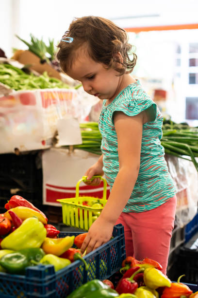 istock Kid shopping in vegetable market. 1190964680