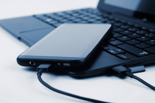 istock Touchscreen phone connected to a laptop 1190969932