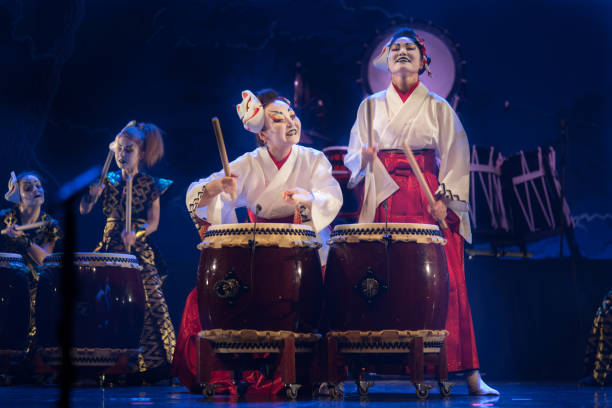 actuación tradicional japonesa. grupo de actrices en kimono tradicional y máscaras de zorro tambortaiko tambor en el escenario. - taiko drum fotografías e imágenes de stock