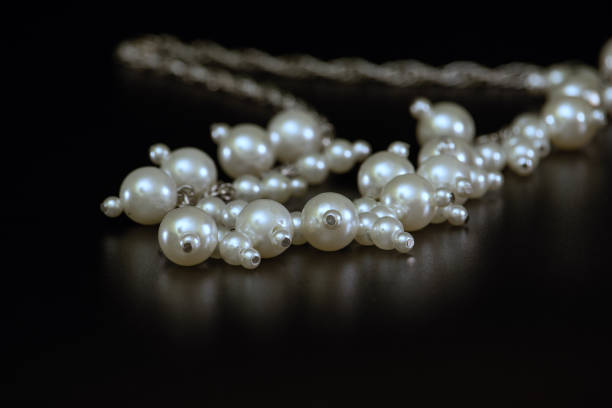 perles de mère de perle sur un fond noir avec la réflexion. - black pearl pearl horizontal necklace photos et images de collection