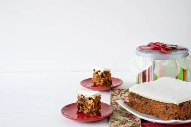 Rich Fruit Christmas Cake on Table with Present on light background with copy space horizontal