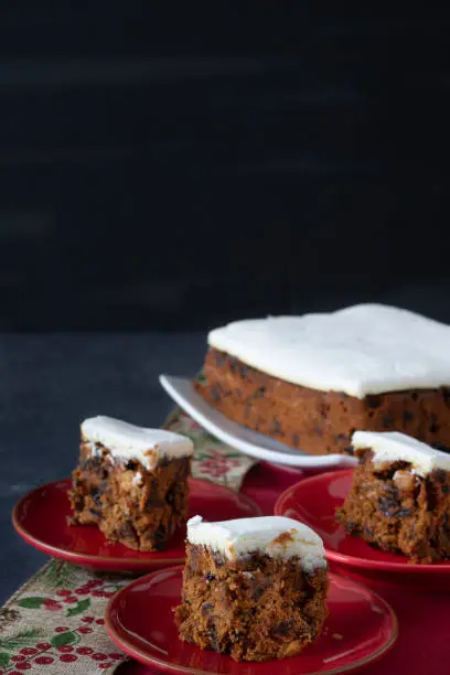 Rich Fruit Christmas Cake on Table with Present on Dark background with copy space Vertical