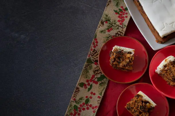 Rich Fruit Christmas Cake on Table with Present on Dark background with copy space from Above